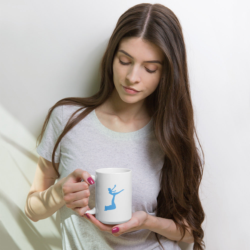 Woman holding a white mug with a blue design against a light background