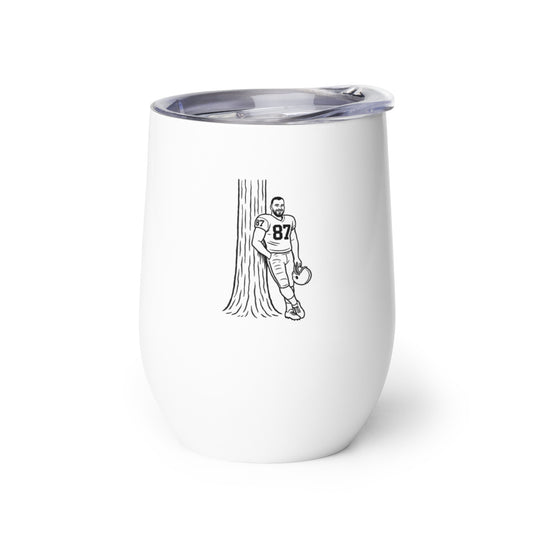White tumbler with a black illustration of a person holding a football next to a tree on a white background