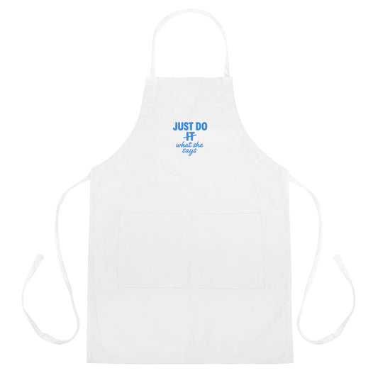 White apron with Just Do What She Says printed on it.